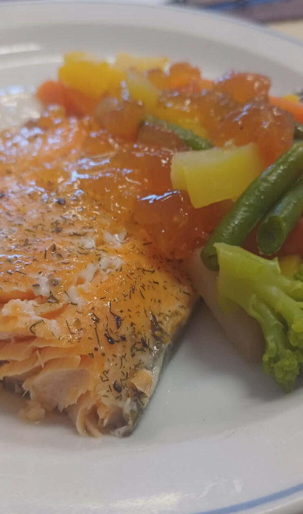 Lautasella maustettu lohifilee, jonka lisukkeena on höyrytettyä parsakaalia, vihreitä papuja, porkkanaa ja maukasta kastiketta