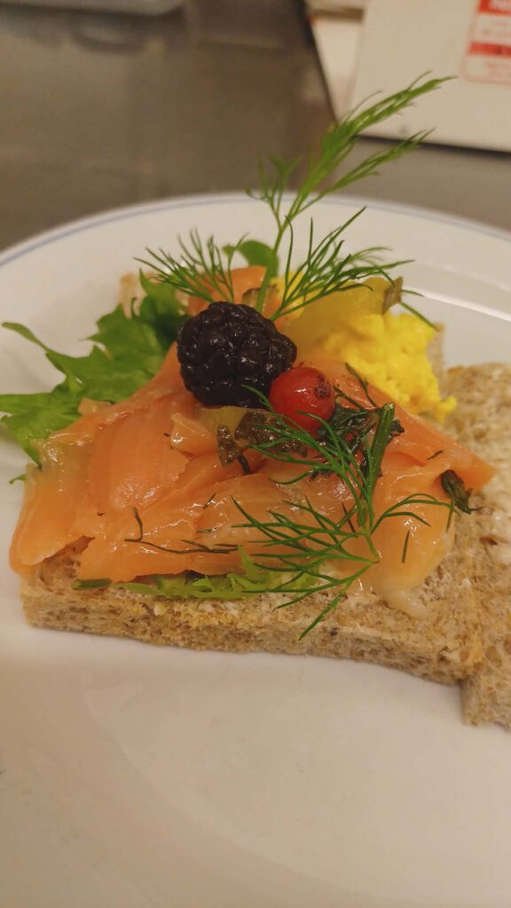 A gourmet salmon appetizer from Linda's Retro Café, featuring fresh seafood and vibrant garnishes